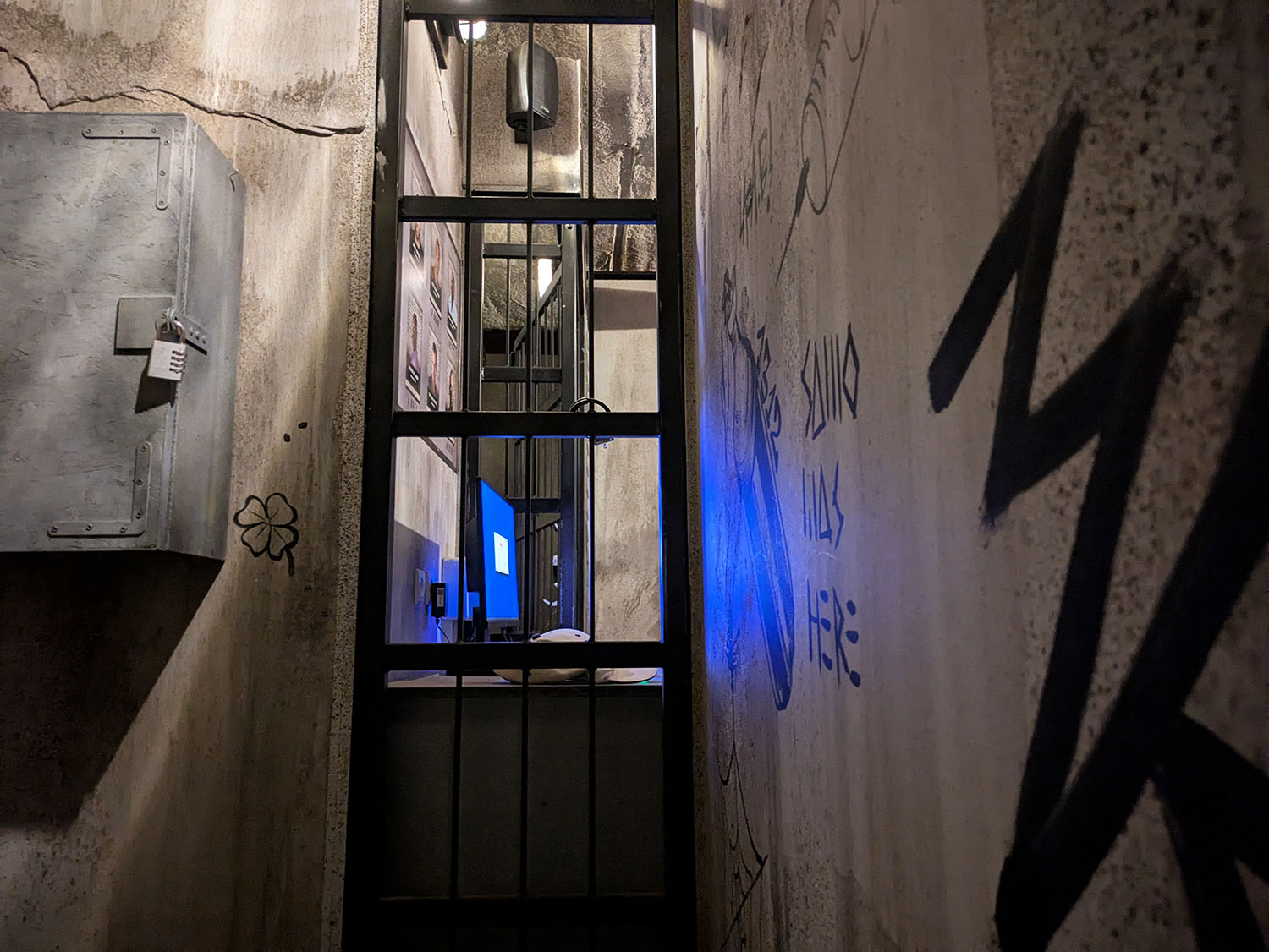 Une grille et des murs couverts de graffitis, décor de Prison Break Asylum chez Team Break Paris 9