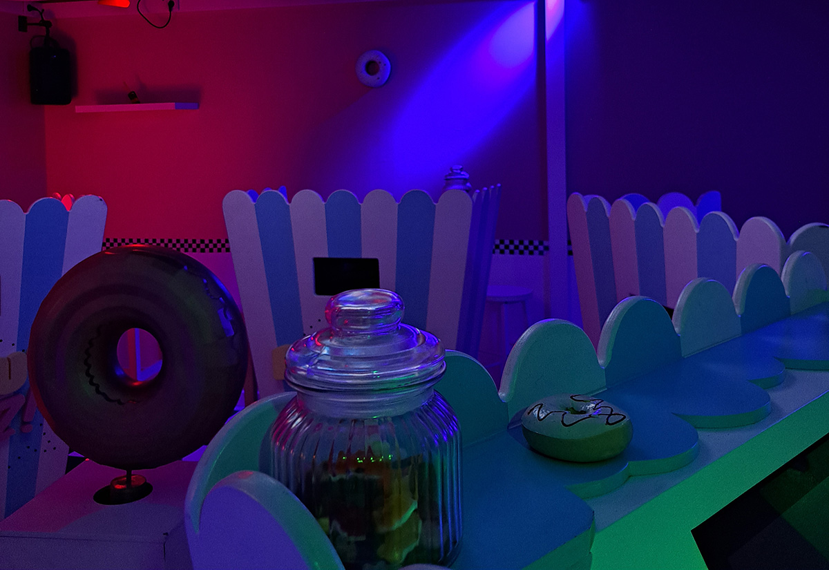 Les pupitres et le décor pastel de la salle Donut Quiz à Lille