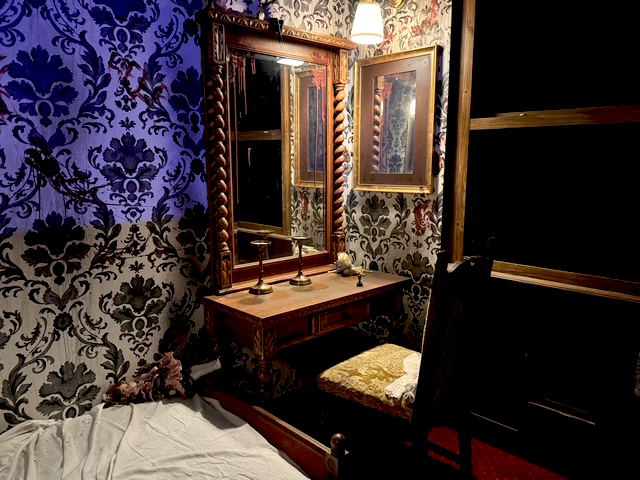 Une coiffeuse et son miroir dans une chambre tapissée, salle Haunted Room à Aéroville