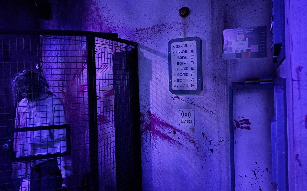 Un zombie derrière le grillage du sas, salle Walking Dead à Lille