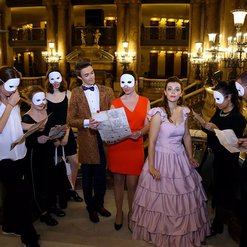 Des comédiens en costume d'époque entourés de joueurs masqués