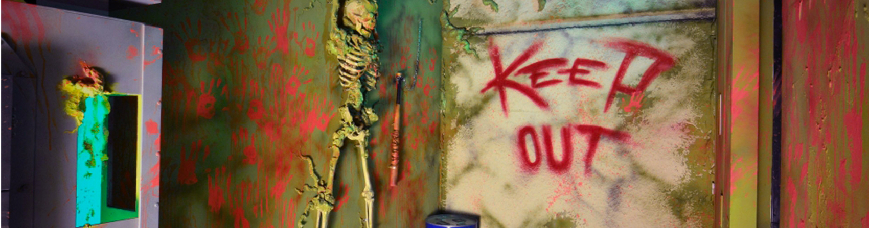 Un squelette accroch&eacute; au mur et l&rsquo;inscription Keep Out, salle Walking Dead