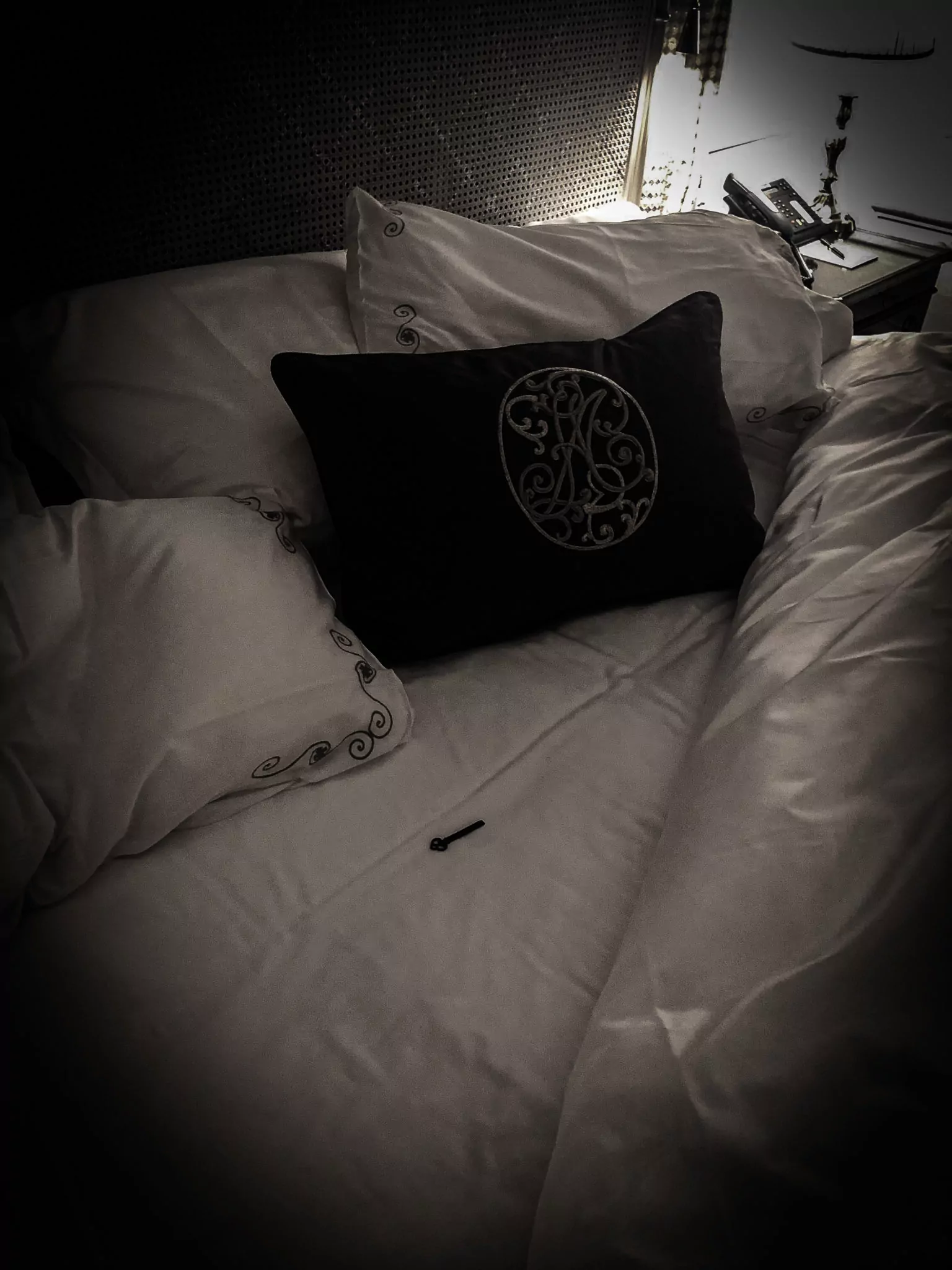 Un coussin brodé sur le lit de la suite