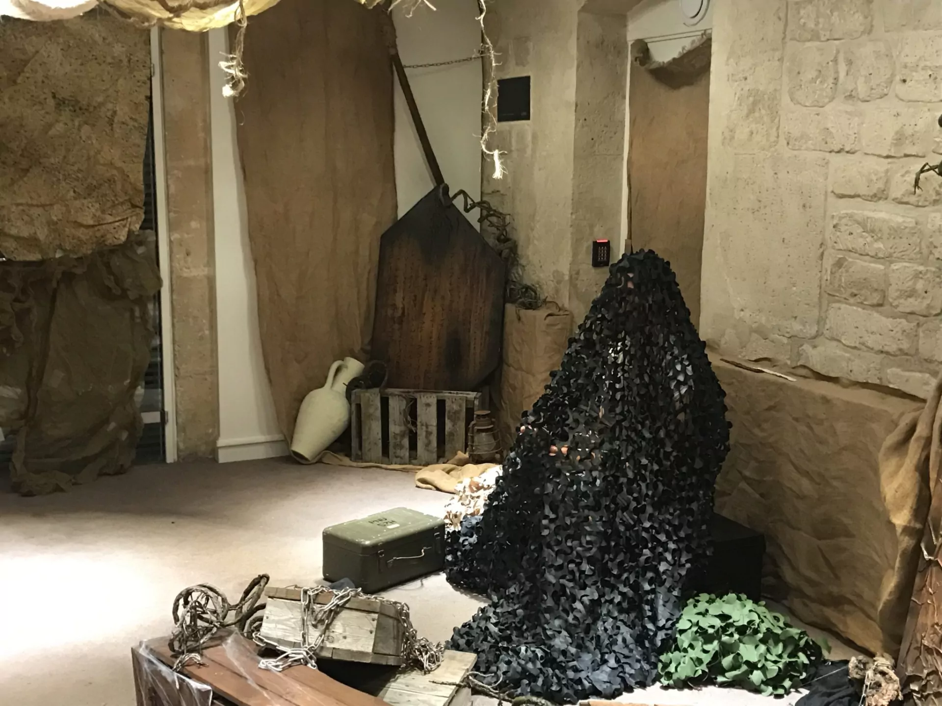 Un coin du décor, entre filet de camouflage et jarres