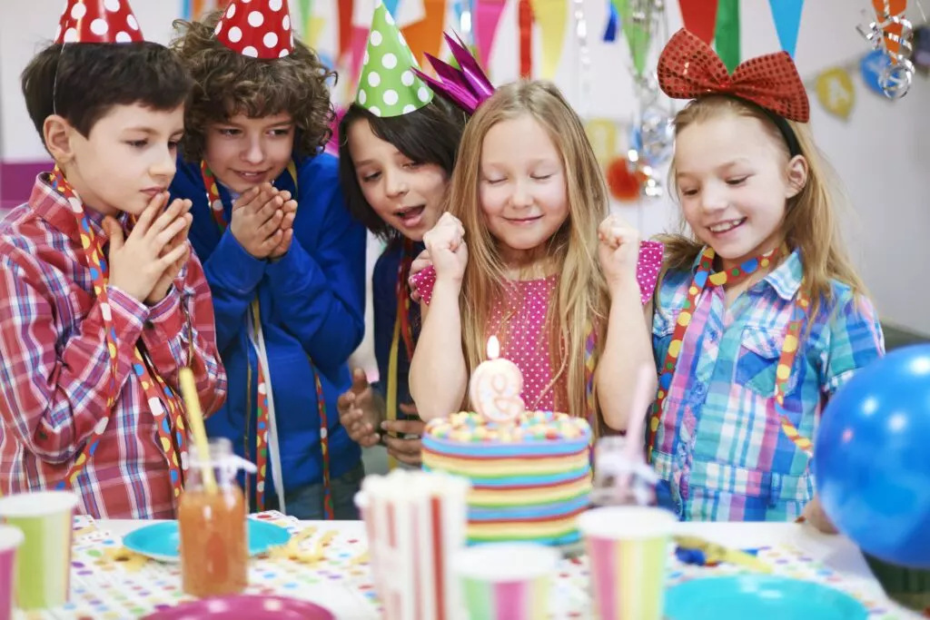 Des enfants devant un gâteau d'anniversaire