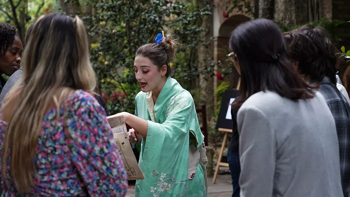 Une comédienne en kimono tend un indice aux joueurs