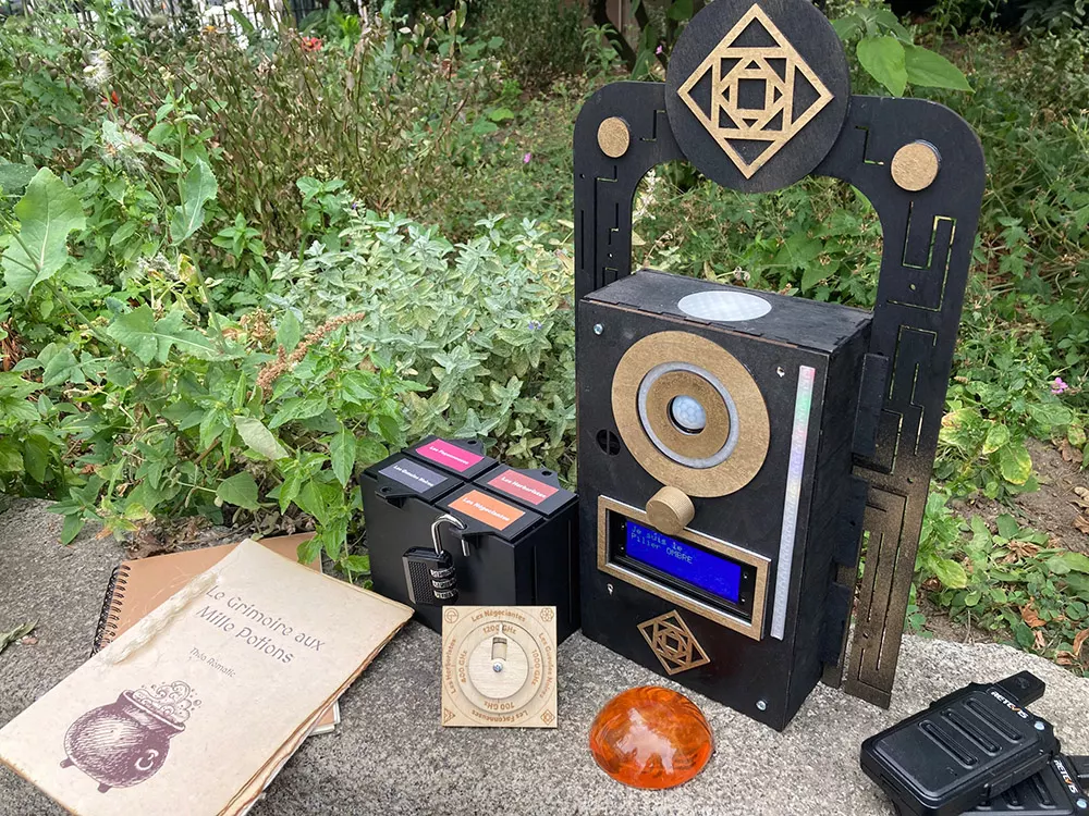 Un pilier et son matériel d'énigmes : grimoire, cadenas, boîtes